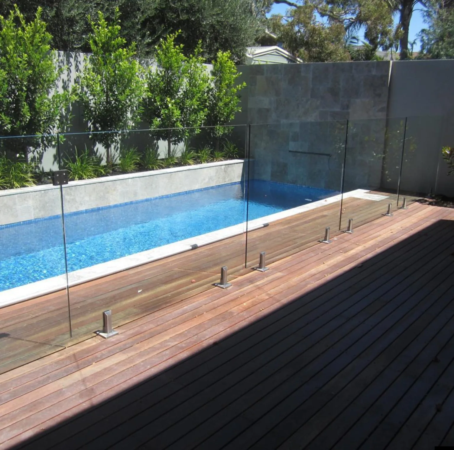 Cierre de vidrio para piscina con fijaciones puntuales junto a deck